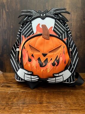 Loungefly Black & White Jack Skellington Holding Flaming Orange Pumpkin Backpack
